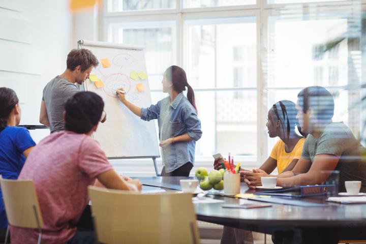 Business executive discussing with their colleagues on the whiteboard