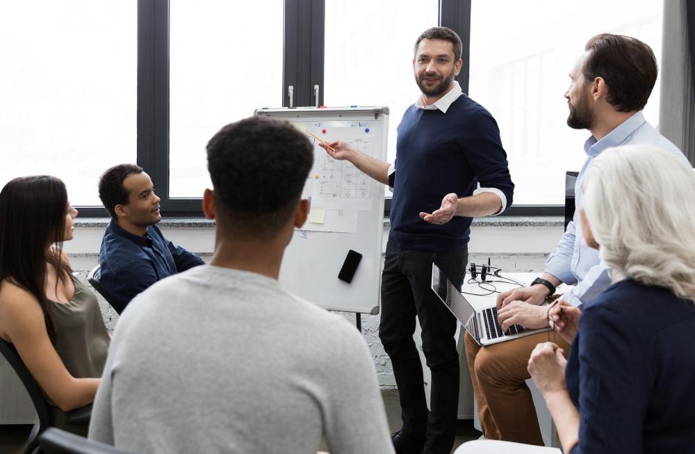 Person presenting an idea on a poster board to a group of colleagues.